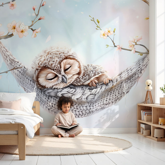 Papier peint chambre bébé | Petite chouette endormie dans un hamac tricoté parmi les fleurs de cerisier